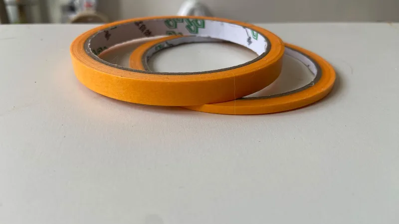 Los dos rollos de cinta de reserva naranja, de 9 mm y de 3 mm, sobre una mesa blanca