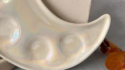 Frascos de lustre arcoiris junto a piezas de cerámica con reflejos tornasolados